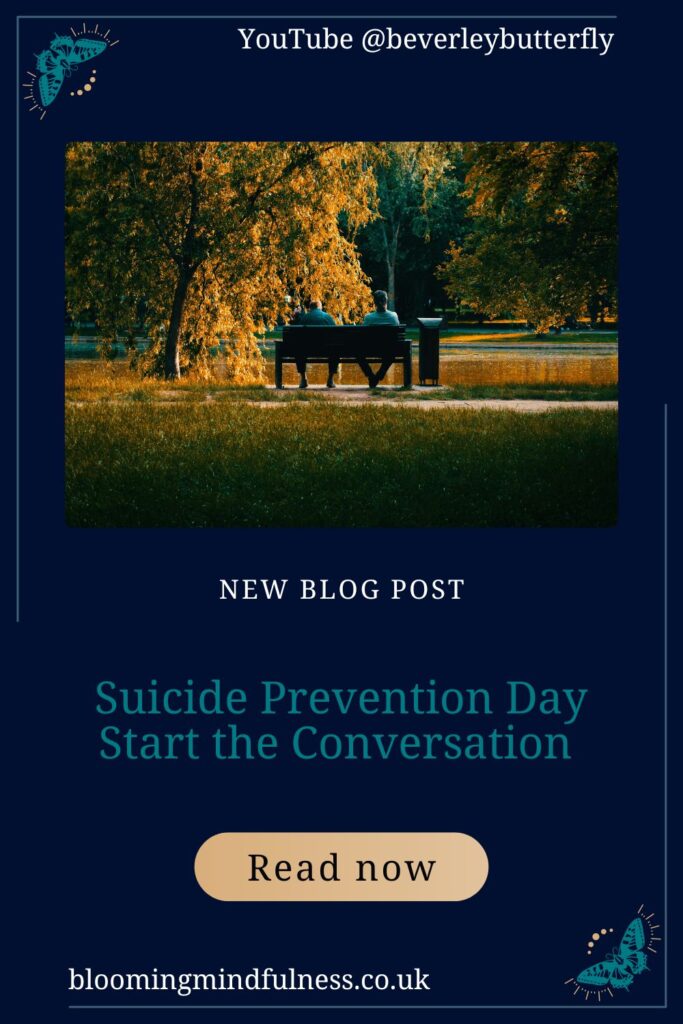 Two people seen from a distance talking on a bench. All around them are beautiful trees in autumnal colours to represent world suicide prevention day