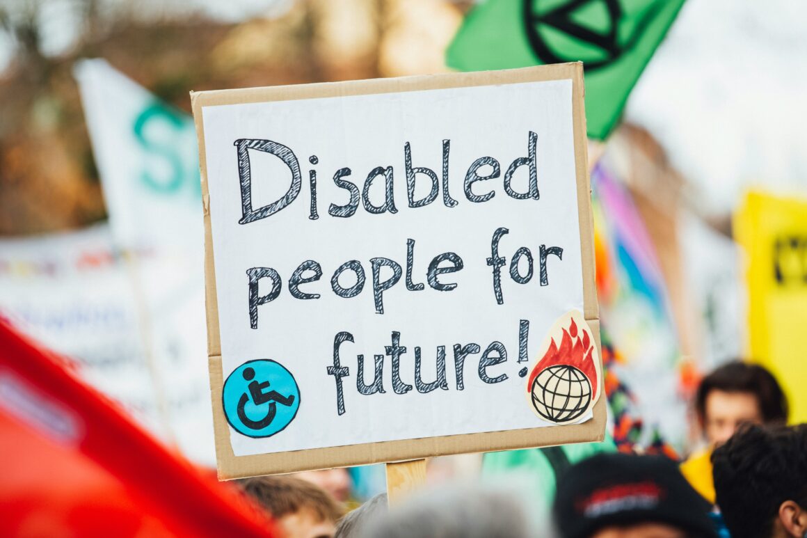 A sign that says 'Disabled people for future' at a rally to represent Disability Pride Isn't About Loving Your Disability